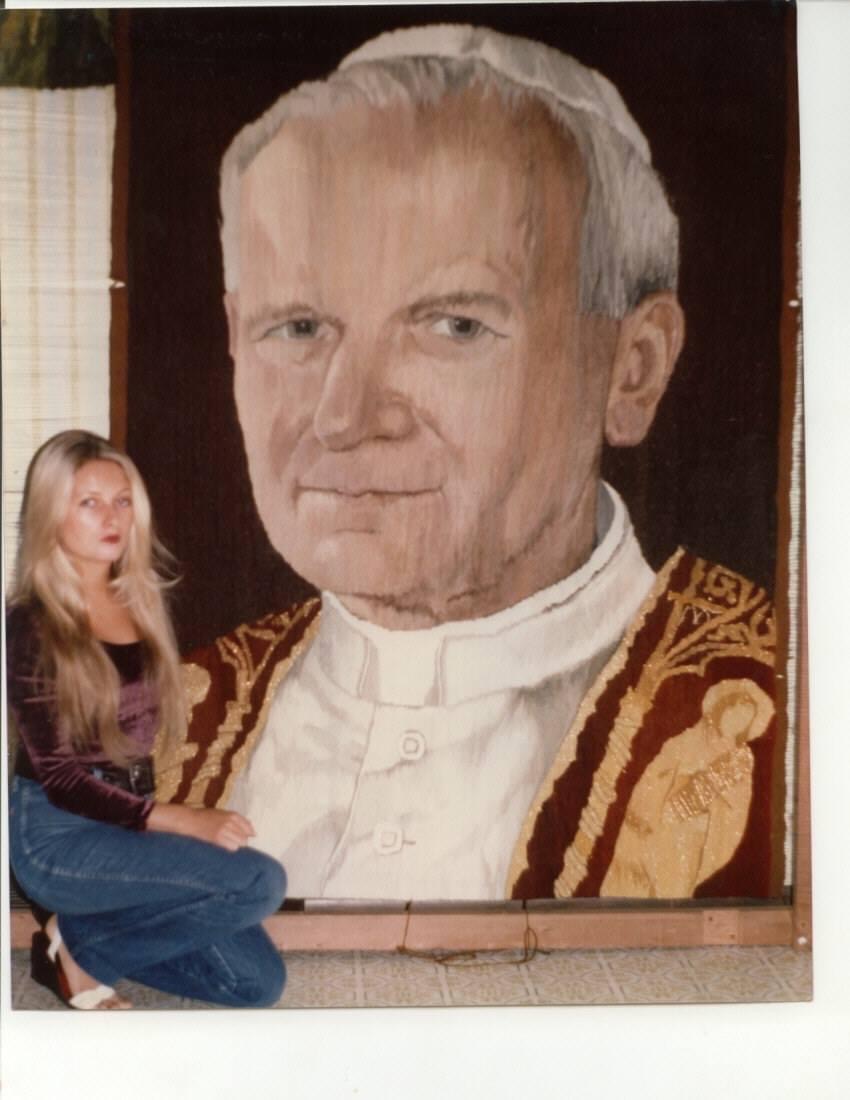 Lehman standing in front of tapestry of John Paul II